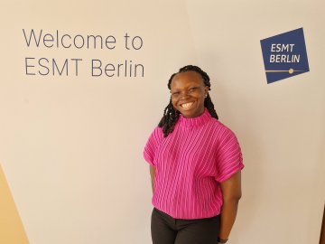 ESMT Berlin Part-time MBA student Funmi Odunowo on the school campus. She is wearing pink and smiling.