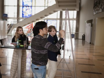 The ESMT Berlin Master in Innovation and Entrepreneurship students working on a group project during the Ideation Bootcamp. You can see the campus stained glass window in the background.