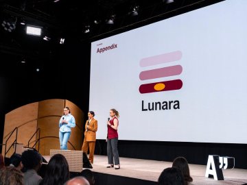 ESMT Berlin Master in Innovation and Entrepreneurship students Jasmin Mantwill, Laura Ruiz, and Gwyneth-Tyger Carys Neumann presenting on stage at the Innova conference