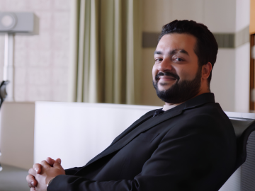 ESMT Berlin Part-time MBA student Max Rafaat giving an interview in a auditorium on campus