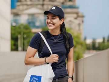 ESMT Berlin Full-time MBA alum Farah Nafi' in central Berlin, walking around the city with an ESMT tote bag