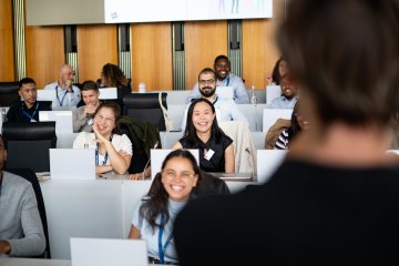 ESMT Berlin MBA students in a lecture. They are smiling at the professor