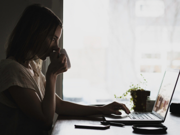 Woman on computer drinking coffee