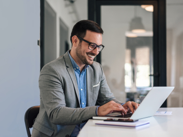 Man working on the computer and smiling. 