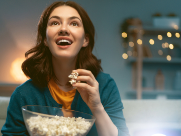 Woman watching a move and eating popcorn