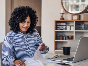 Female sitting at table working from home on laptop