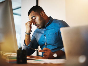 Tired man sitting in front of computer monitor. 