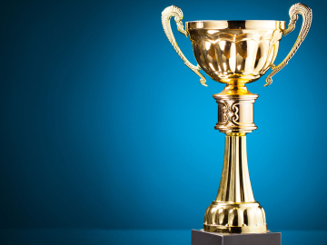 Gold cup trophy on blue background