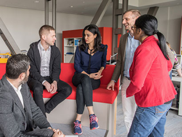 5 executives having a discussion in a library
