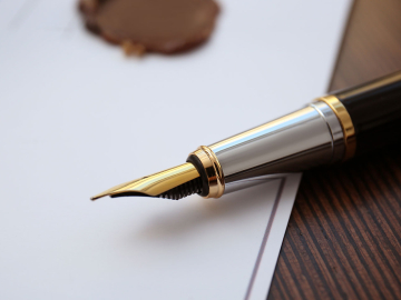 Fountain pen lying on paper on a table 