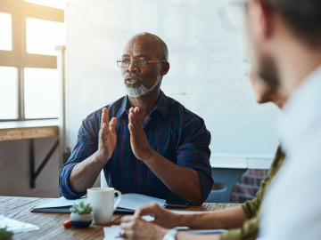 African American male leading a business meeting