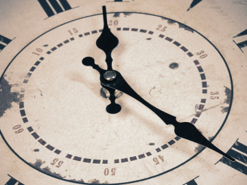 Old clock in Roman numerals, reading 20 minutes past 12