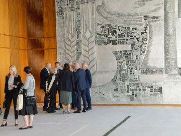 people in front of the aluminium relief in the sitzungsaal