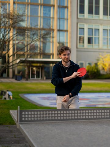 Master's student Alexander Berner playing table tennis in the ESMT Berlin gardens