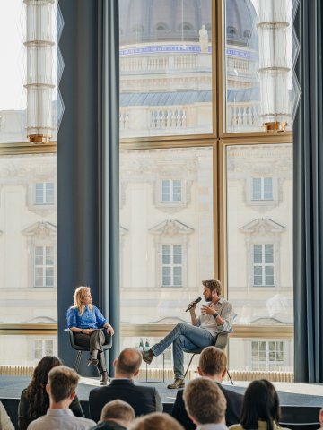 Speakers on stage at a panel discussion on the ESMT campus