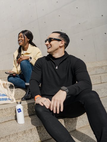 Full-time MBA student Gloria Mopotu and students from ESMT Berlin sitting on stairs 