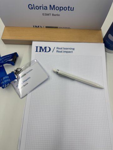 ESMT Berlin student Gloria Mopotu shows her GNAM week notepad and name badge