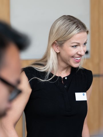 An ESMT Berlin Global Online MBA student. She is taking part in the Berlin Experience Week and smiling while being part of a group project