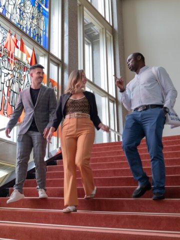 Part-time MBA students on campus  walking past the stained glass window