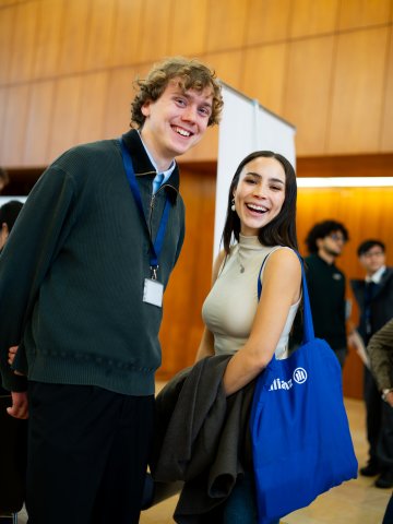 Master's students checking out the employer booth area and smiling at the ESMT Berlin Career Fair