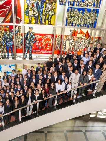 The ESMT master's students from the Class of 2027 gathering on the staircase for a group photo
