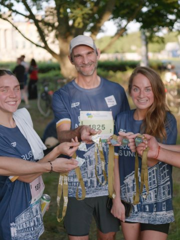 ESMT Berlin students and faculty show their medals after running the Berliner Wasserbetriebe 5 x 5 relay race together