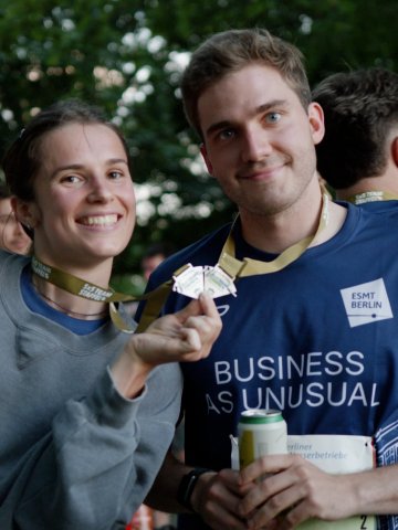 ESMT Berlin students show their medals after running the Berliner Wasserbetriebe 5 x 5 relay race together