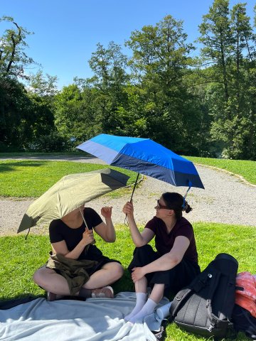 ESMT Berlin Full-time MBA students Beatriz Sgobi and Ieva Cerniauskaite in the sunshine with big umbrellas