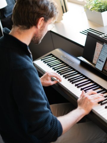 ESMT Berlin Master in Innovation and Entrepreneurship student Alexander Berner at the piano in the campus student lounge 