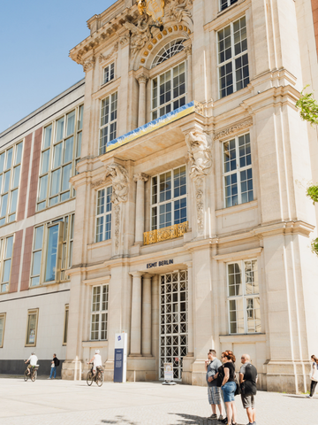 Main entrance to the historic ESMT Berlin campus with visitors outside.
