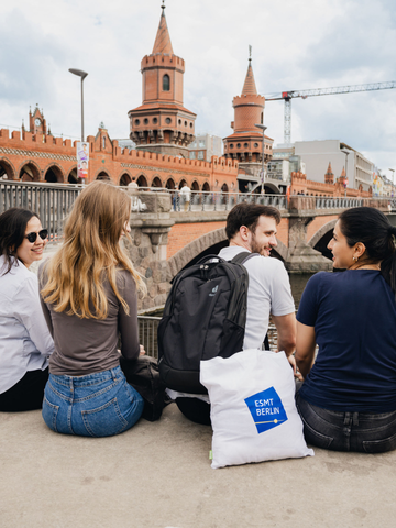 ESMT Berlin students sitting by the River Spree near the Oberbaum Bridge in Berlin.