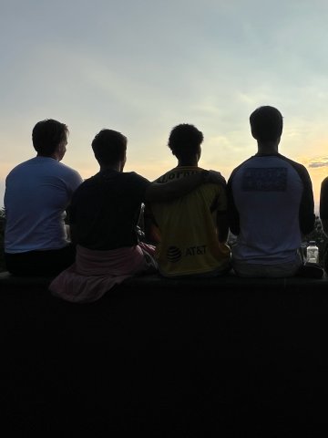 Sillouettes of ESMT Berlin Master in Analytics and AI  student Fynn Barkhausen  and classmates watching the sunset from a lookout during an exchange in Mexico