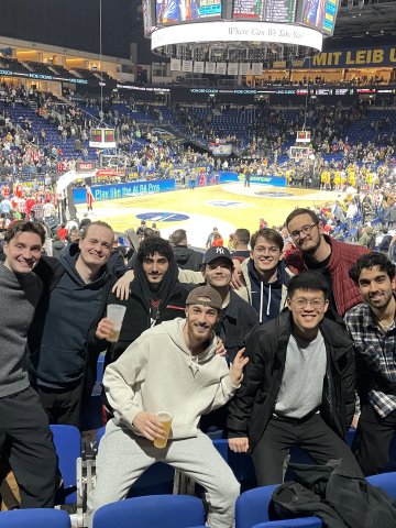 ESMT Berlin Master in Analytics and AI  student Fynn Barkhausen  and classmates at a football game in a crowded stadium