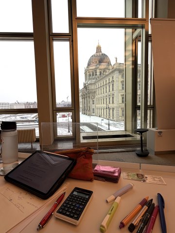 View of a student's workspace at ESMT Berlin, with a view of the Humboldt forum outside the window