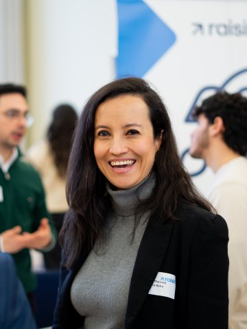 An ESMT Berlin student standing in front of hiring company booths at the Career Fair