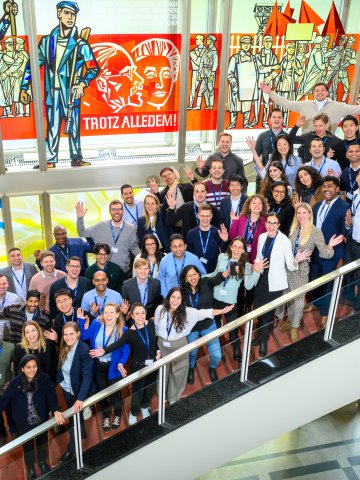 The ESMT Berlin Part-time MBA Class of 2026 posing together on the main staircase on campus 