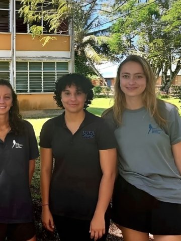 ESMT Berlin Master in Global Management students Six young adults smiling outdoors by a tree in front of a school building in the Seychelles