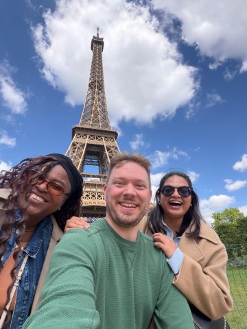 ESMT Berlin Full-time MBA students Roshni, Scott, and Tammy at the Eiffel Tower on a class trip to Paris