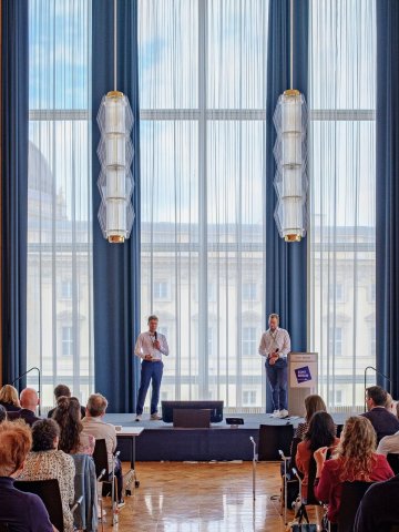 Students giving a speech on stage in the grand auditorium on campus at EMST Berlin