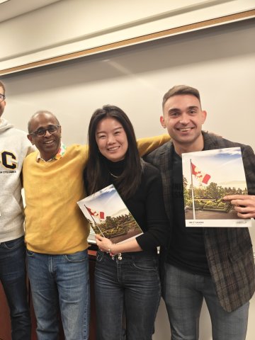 ESMT Berlin Part-time MBA student Pavel Seraphimov and fellow exchange students holding up their UBS SAuder merch
