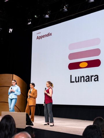 ESMT Berlin Master in Innovation and Entrepreneurship students Jasmin Mantwill, Laura Ruiz, and Gwyneth-Tyger Carys Neumann presenting on stage at the Innova conference
