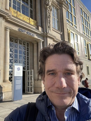 Marcus Waldmann taking a selfie while standing outside the main entrance of ESMT