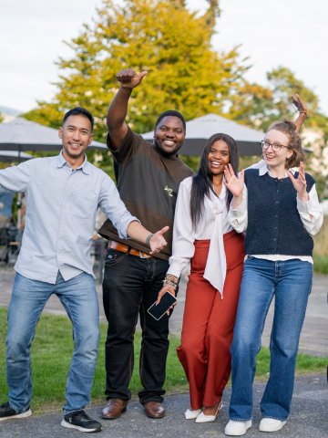 A group of ESMT Berlin Global Online MBA students smiling in the campus garden during Berlin Experience Week