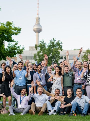 ESMT Berlin Global Online MBA students Jsmiling for the camera while in the campus garden during Berlin Experience Week