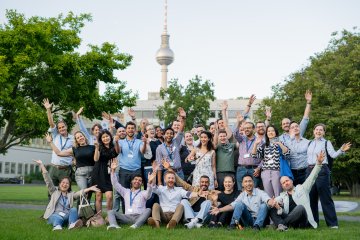ESMT Berlin Global Online MBA students Jsmiling for the camera while in the campus garden during Berlin Experience Week
