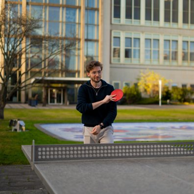 Master's student Alexander Berner playing table tennis in the ESMT Berlin gardens