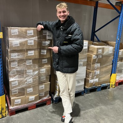 Master in Global Management student Lucas Wall smiling at the camera while visiting a METRO warehouse as part of his internship