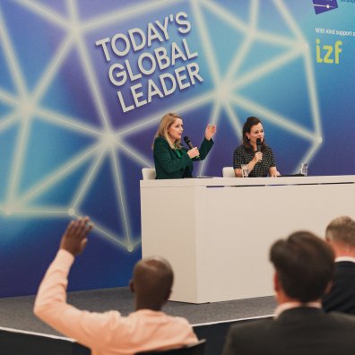 A photo of an on-stage discussion from Today's Global Leader with Bonita Grupp, managing partner of TRIGEM