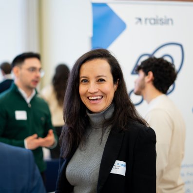 An ESMT Berlin student standing in front of hiring company booths at the Career Fair
