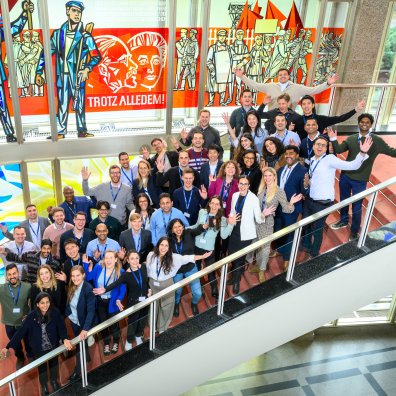 The ESMT Berlin Part-time MBA Class of 2026 posing together on the main staircase on campus 